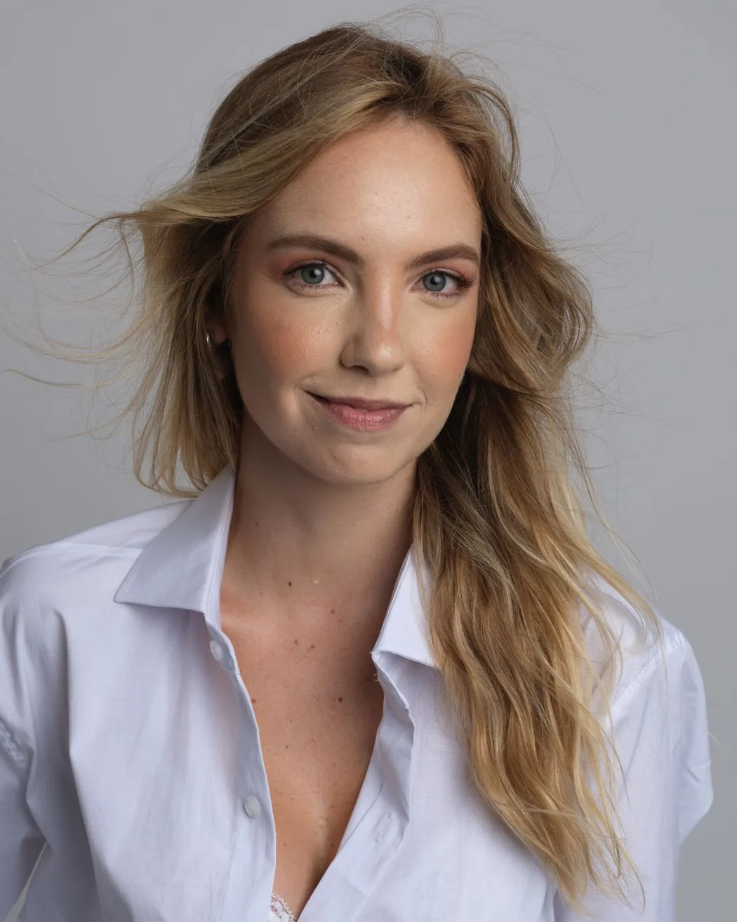 Dana, founder and nurse practitioner, in a white shirt against a warm grey background