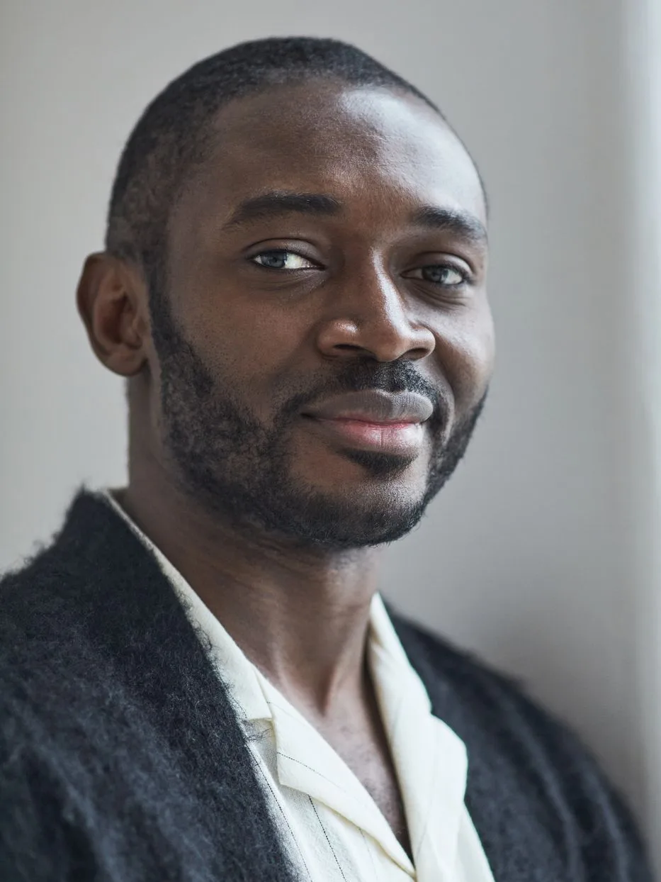 Cole, patient coordinator, in a dark collar against a soft grey background