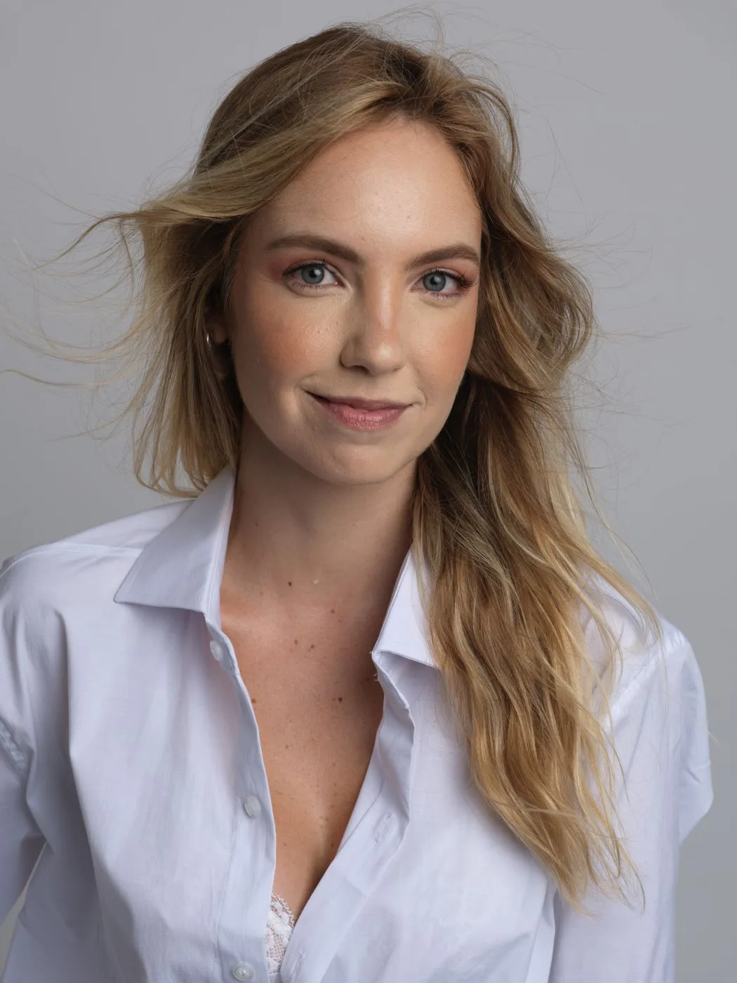 Dana, founder and nurse practitioner, in a white shirt against a warm grey background