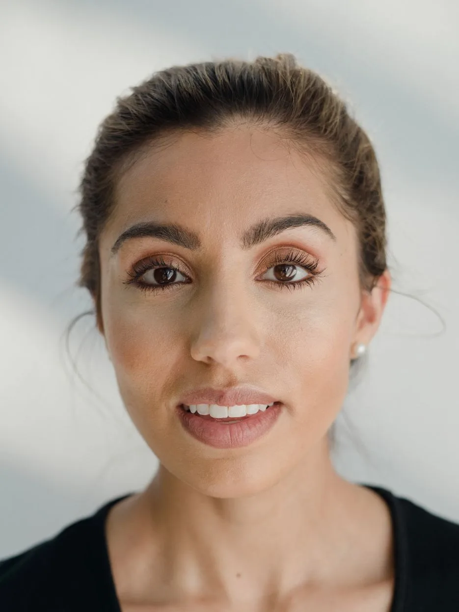 Mara, master esthetician, dark hair pulled back, against a soft light background